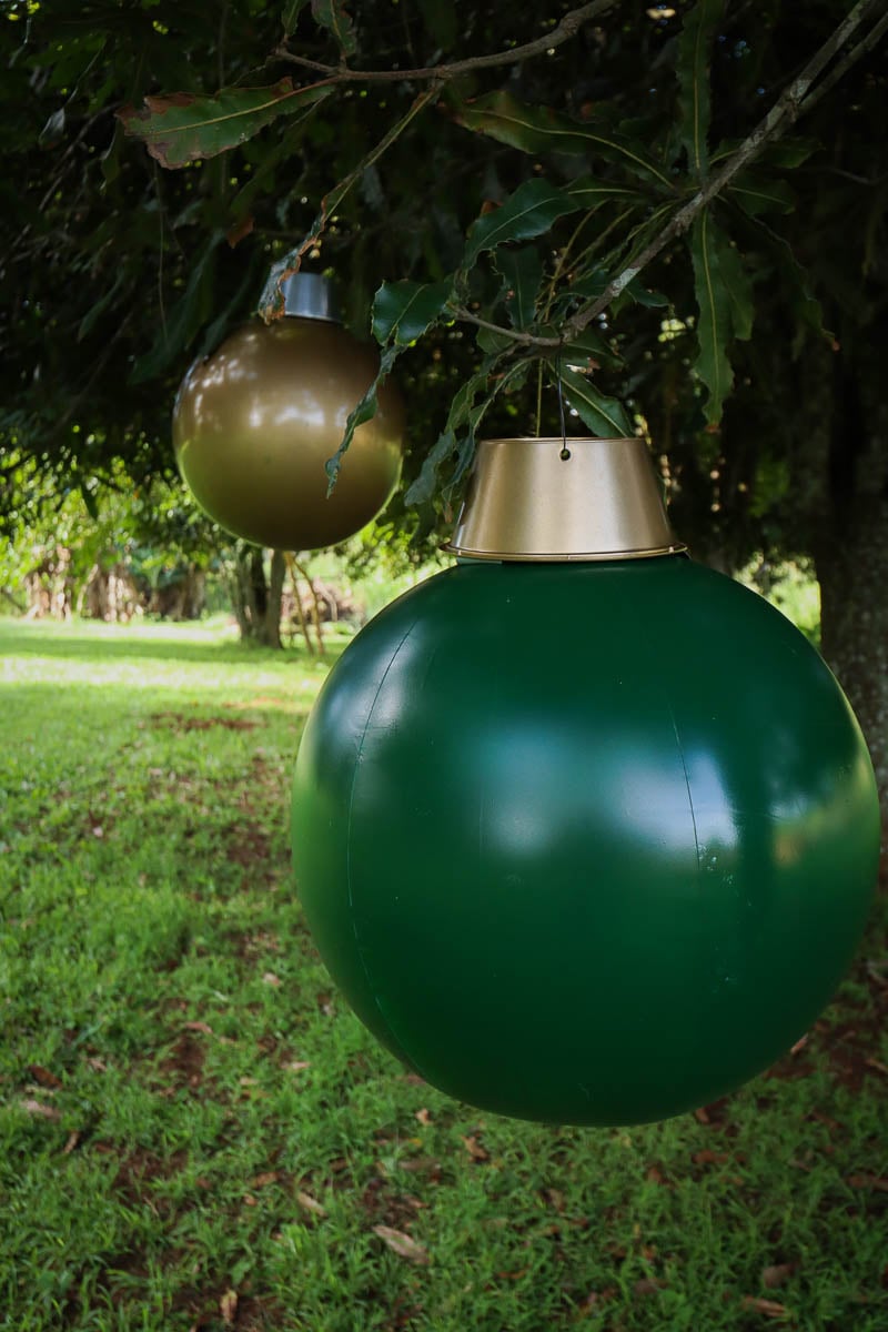 Giant outdoor Christmas baubles hanging from a tree