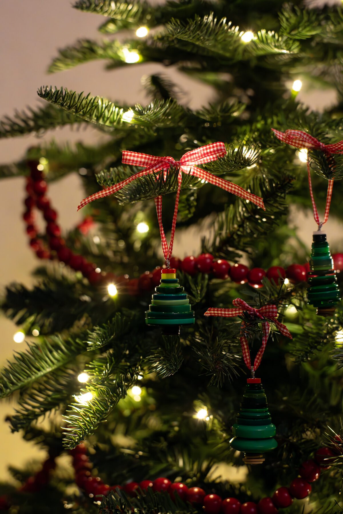 Button Christmas tree ornaments on a Christmas tree.