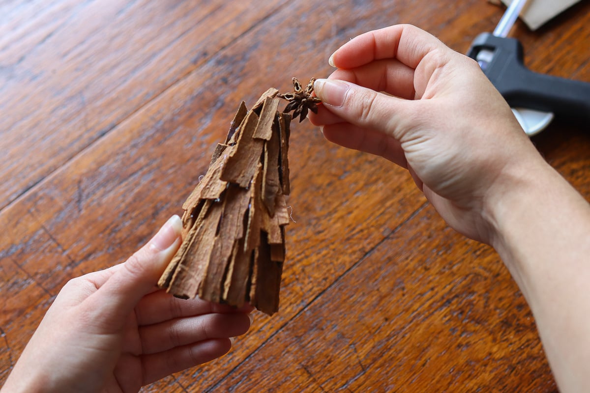 Gluing star anice to cinnamon stick Christmas tree