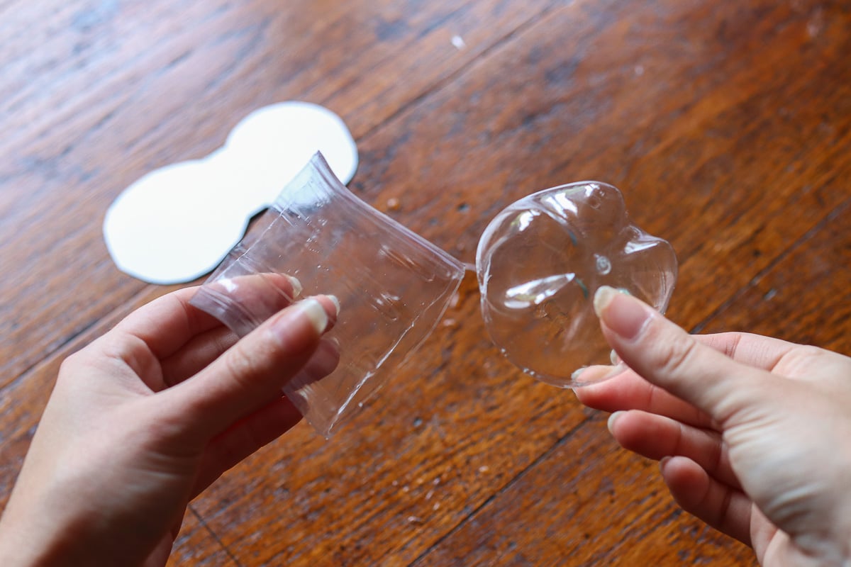 woman's hands holding soda bottle cut in half