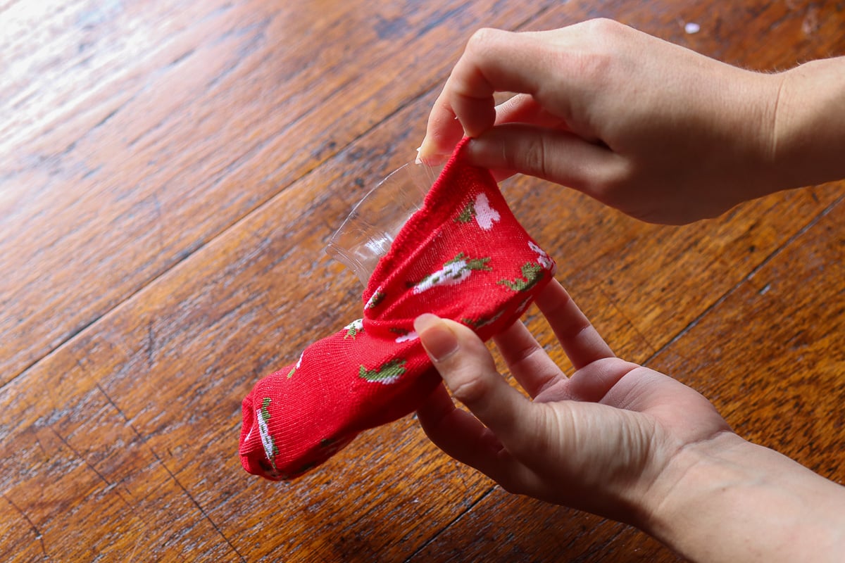 Woman's hand putting sock on boot form