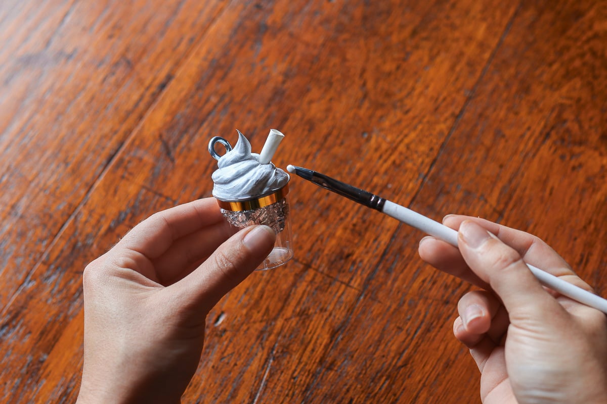 Woman's hands painting a hot chocolate Christmas ornament