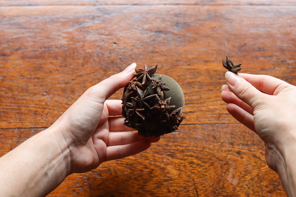 Woman gluing star anise to baubles
