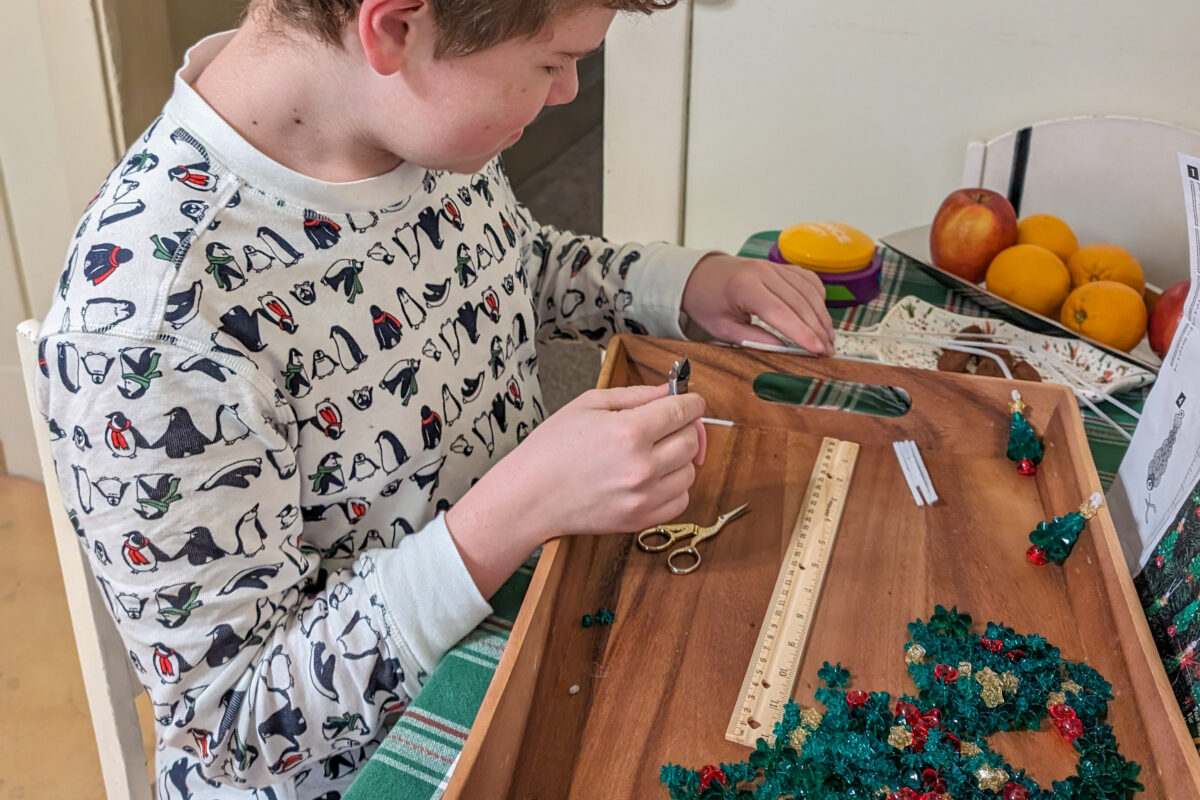 Child assembling beaded ornaments